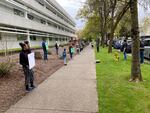 Child care providers hold signs asking Oregon Gov. Kate Brown to support their industry. Providers say they've been financially impacted by coronavirus and Brown's loosened requirements for emergency child care providers.