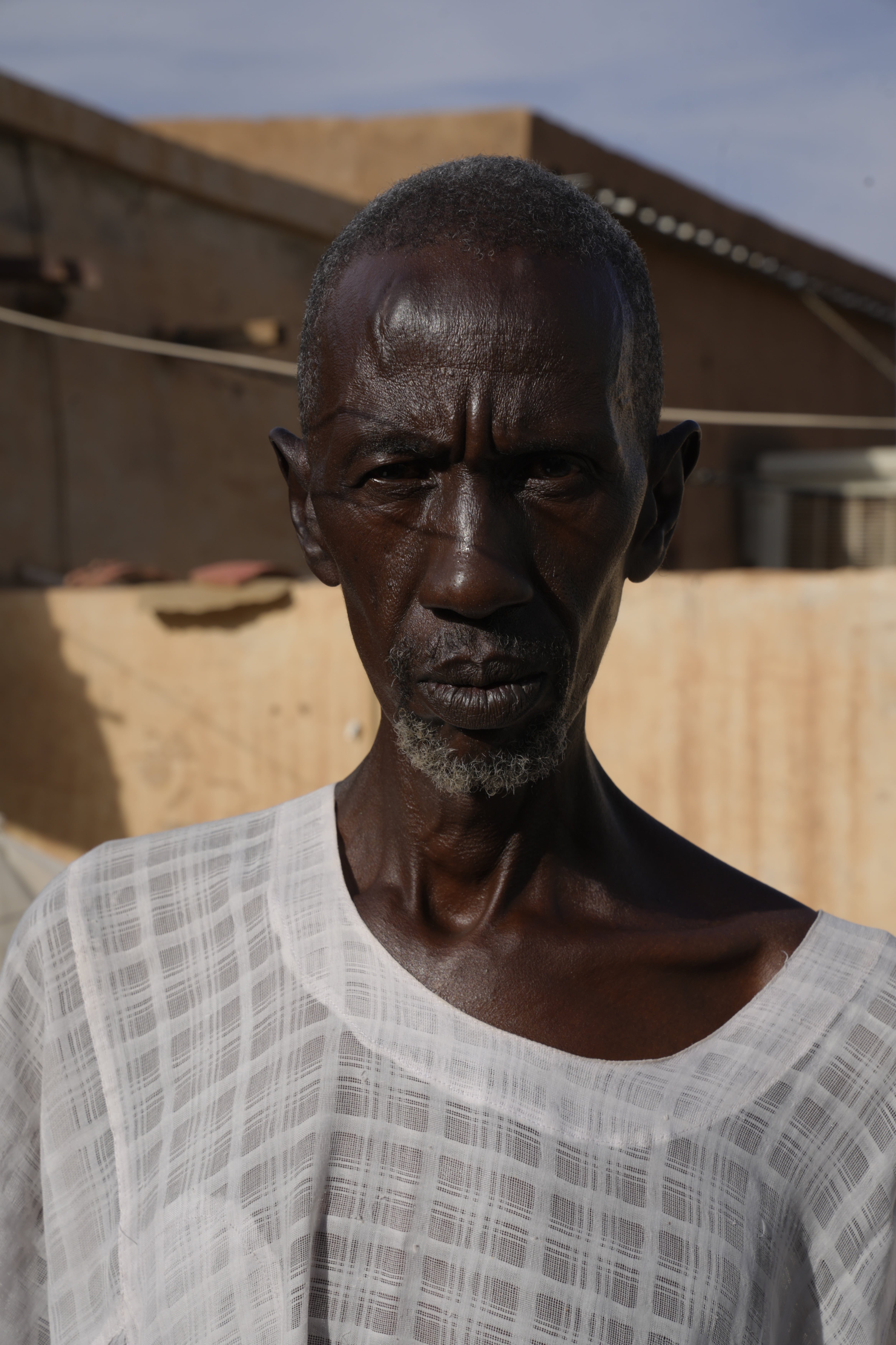 Ahmed Uduma, 63, at his home in Khartoum. His family escaped to Port Sudan at the start of the war but he refused to leave.<br>