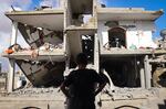 A Palestinian youth stands in front of a destroyed building following Israeli bombardment of Rafah's Tal al-Sultan district in the southern Gaza Strip on Tuesday. The Israeli army said it took "operational control" of the Palestinian side of the Rafah border crossing between Gaza and Egypt and that troops were scanning the area.