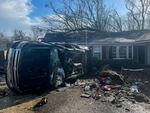 A damaged vehicle rests on its side in front of a home, Thursday, in Selma, Ala. A large tornado damaged homes and uprooted trees in Alabama on as a powerful storm system pushed through the South.