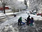 Children take to a snowy street next to Northeast Portland's Sabin School on a snow day, Feb. 21, 2018.