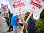 Boeing workers hold signs on the picket line at the Renton assembly plant on Friday in Renton, Wash.