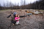 Lynne Piper and her daughter Ada, 4, play near the remains of their Elkhorn home, Feb. 26, 2021. The Piper family had only owned their 17-acre property in Elkhorn a short time before it was destroyed by the 2020 Santiam fire. 