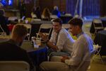 A group of young men in embroidered shirts enjoy a drink while waiting for the dance floor to fill up.