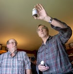 Sen. Jeff Merkley examines a water sample clouded with sediment at Dick Zimmerlee's home in Prineville, Ore., on June 9, 2024.