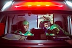 Paramedics Papinki Lebelo (left) and Zuko Faltein look up the details of the next patient they'll be seeing on a screen in their ambulance in Cape Town, South Africa.