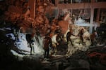 Israeli security forces inspect a destroyed building that was hit by a missile fired from Iran, near Tel Aviv, Israel, early Sunday, June 15, 2025. 