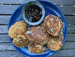 Zucchini fritters with sauce on a blue plate.