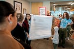 Vasiliki Touhouliotis, left, holds up the Oregon Employment Relations Board's order with a PSU student in President Ann Cudd’s office in downtown Portland, Ore., on Thursday, Oct. 16, 2025.