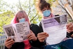 FILE: Mia Rose of Eugene, left, and Samira Jensen of Portland read literature as they attend a rally at Pioneer Courthouse in Portland, Ore., April 22, 2024, organized by Stop The Sweeps PDX. The U.S. Supreme Court sided with the city of Grants Pass on Friday, June 28, 2024, in finding that local governments have the ability to remove outdoor homeless encampments. 