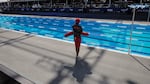 A lifeguard overlooks an outdoor swimming pool.