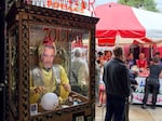 A Paul Hollywood mask covers an automated fortune teller in the foyer of Portland’s Pix Pâtisserie on June 27, 2026. It's part of transforming the space into the set for the Big Portland Bake Show, a riff on the British reality TV baking competition.