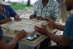 A group of men play dominoes at the Antonio R. Barceló Plaza in Barrio Obrero, the heart of the Dominican community in Puerto Rico.