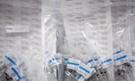 Vaccine doses are prepared in syringes and packaged in zippered plastic bags.