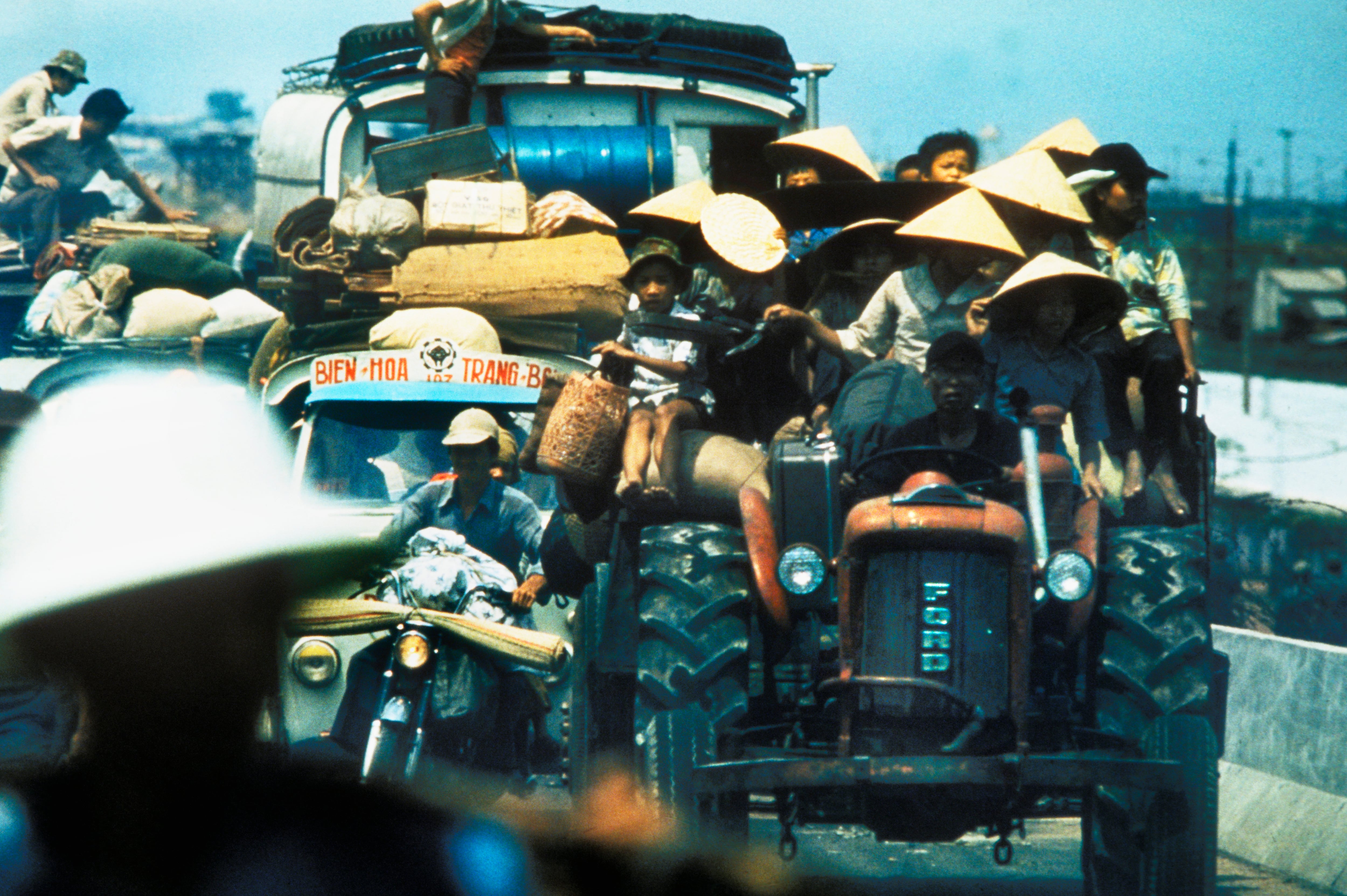 Desperate South Vietnamese refugees cling to vehicles along Highway 1 as they flee North Vietnamese troops advancing to capture Saigon a few days before the fall of Saigon that signaled the end of the Vietnam War.