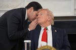 Secretary of State Marco Rubio whispers to President Donald Trump, who is holding the note Rubio handed to him to warn of impending ceasefire deal.