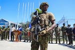 A Kenyan police officer, part of a UN-backed multinational force, stands guard on the tarmac during a ceremony to welcome police officers from the Bahamas at the Toussaint Louverture International Airport in Port-au-Prince, Haiti, Friday, Oct. 18, 2024.