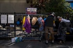 People look through the costume rack, nicknamed "Operation Inflation" outside the U.S. Immigration and Customs Enforcement facility in Portland, Ore., on Wednesday, Oct. 15, 2025.