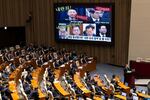 A screen displays photographs of South Korean President Yoon Suk Yeol (top left) and former and current cabinet ministers, accusing them of treason, during a plenary session at the National Assembly in Seoul, South Korea, on Wednesday. Yoon looks set to fight on rather than step down early as probes deepen into his martial law declaration and another likely impeachment bid loom.