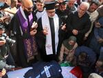 Priests and friends mourn over the body of veteran Al Jazeera Palestinian journalist Shireen Abu Akleh Wednesday, after she was shot dead as she covered an Israeli army raid on the West Bank's Jenin refugee camp.
