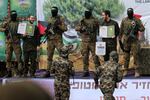 Israeli hostage Eliya Cohen (L) and Omer Shem Tov smile to each other as they stand on stage accompanied by Hamas fighters in Nuseirat in the central Gaza Strip, after their release as part of the seventh hostage-prisoner exchange on February 22, 2025.