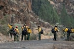 FILE - Wildland firefighters create a fire break on the side of Rowe Creek Road near Mitchell, Ore., on July 21, 2026.