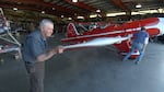 Volunteer Ron Wilkins helps roll a 1937 plane out of the restoration shop to test fire the engine.