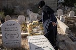 Hanan Khdour, 47, stands beside the grave of her son Mohammad Khdour in Biddu, West Bank, on Sept. 19, 2024. Mohammad, 17, and his cousin Malek Mansour, 16, also from Biddu, were driving in the hills not too far from their home in February 2024, when a man shot at their car from a distance as they were driving back.