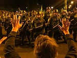 A clergy member holds up his hands as Border Patrol agents move in. 