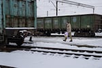 Soldiers hold flowers as they wait for their wives and girlfriends to arrive to the Kramatorsk train station.