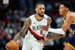 FILE - Portland Trail Blazers guard Damian Lillard (0) brings the ball up the court against Golden State Warriors guard Will Richard, right, during the first half of a preseason NBA basketball game on Wednesday, Oct. 7, 2026, in Portland, Ore.