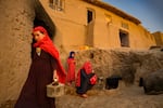 SAMANGAN, AFGHANISTAN - OCTOBER 22: Khalida Nazari, centre, stands with other family members by an outdoor stove in the village of Maqsood in Lower Darisuf on October 22, 2023 in Samangan, Afghanistan. Because of the drought, water for agricultural lands and for drinking water has dried up in most of the villages across the area; no one has been able to grow wheat or other crops for the past three years, and most have sold their animals to survive. After roughly 3500 families fled this village of Maqsood to a nearby town in search of more sustainable living conditions, the Taliban government returned them back to the area, and began trucking drinking water to the remote area daily to prevent people from leaving. Afghanistan is one of the top ten countries affected by climate change, and is suffering from an ongoing drought in a majority of the country.