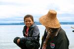 Orion Arabia, 8, Cherokee, sits on a log next to his grandmother, Kathryn Walkingstick, Cherokee at Owen Beach on July 30, 2024, waiting to greet canoe families from dozens of Native nations across the Pacific Northwest on their second to last day of journey.