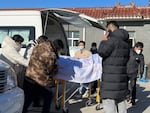 Liang from Beijing, center, looks on as his 82-year-old grandmother is brought in a casket to the Gaobeidian Funeral Home in northern China's Hebei province on Dec. 22, 2022. Liang's grandmother had been unvaccinated when she came down with coronavirus symptoms, and had spent her final days hooked to a respirator in a Beijing ICU.