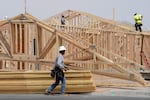 FILE - Construction workers install a lumber roof at a new home build Tuesday, April 1, 2025, in Laveen, Ariz.