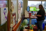 Debbie Hassler, Deputy Director of Cowlitz Indian Tribe’s Health and Human Services department, stands at her desk. Her office is decorated with Native-made and rainbow-themed artwork, stickers and signs that celebrate Two-Spirit identity.