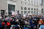 In this photo, supporters of the U.S. Agency for International Development demonstrate outside USAID's headquarters building in Washington, D.C. The people are gathered in a crowd, and some are holding signs.