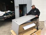 Clint Funderburg unloads a piece of refrigeration equipment for a fishing boat he's working on while he's waiting out uncertain seafood markets.