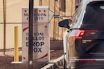 A voter drops a ballot into the ballot drop box at the Maricopa County Tabulation and Election Center in Phoenix, Arizona, on October 23, 2024. With both parties telling their supporters to vote early, concerns about ballot drop boxes are resurfacing in 2024.