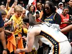 Caitlin Clark, the heralded Indiana Fever rookie, signs autographs after a game against the Washington Mystics that was attended by more than 20,000 fans, the highest attendance for a WNBA game in 17 years.