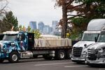 The downtown Portland skyline is seen behind trucks parked at the Daimler facility.