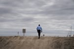 Greg Gatzka walks up a levee to look out over the floodwaters.