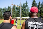 Throwers watch a fellow competitor.