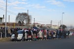 Women wait in line for work outside a garment factory in Maseru, Lesotho. Work here has dried up as the threat of Trump's tariffs have hit a once thriving industry hard.