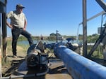 Alan Schreiber inspects his broken irrigation pump. It's only working at 30 percent capacity in 117 heat.