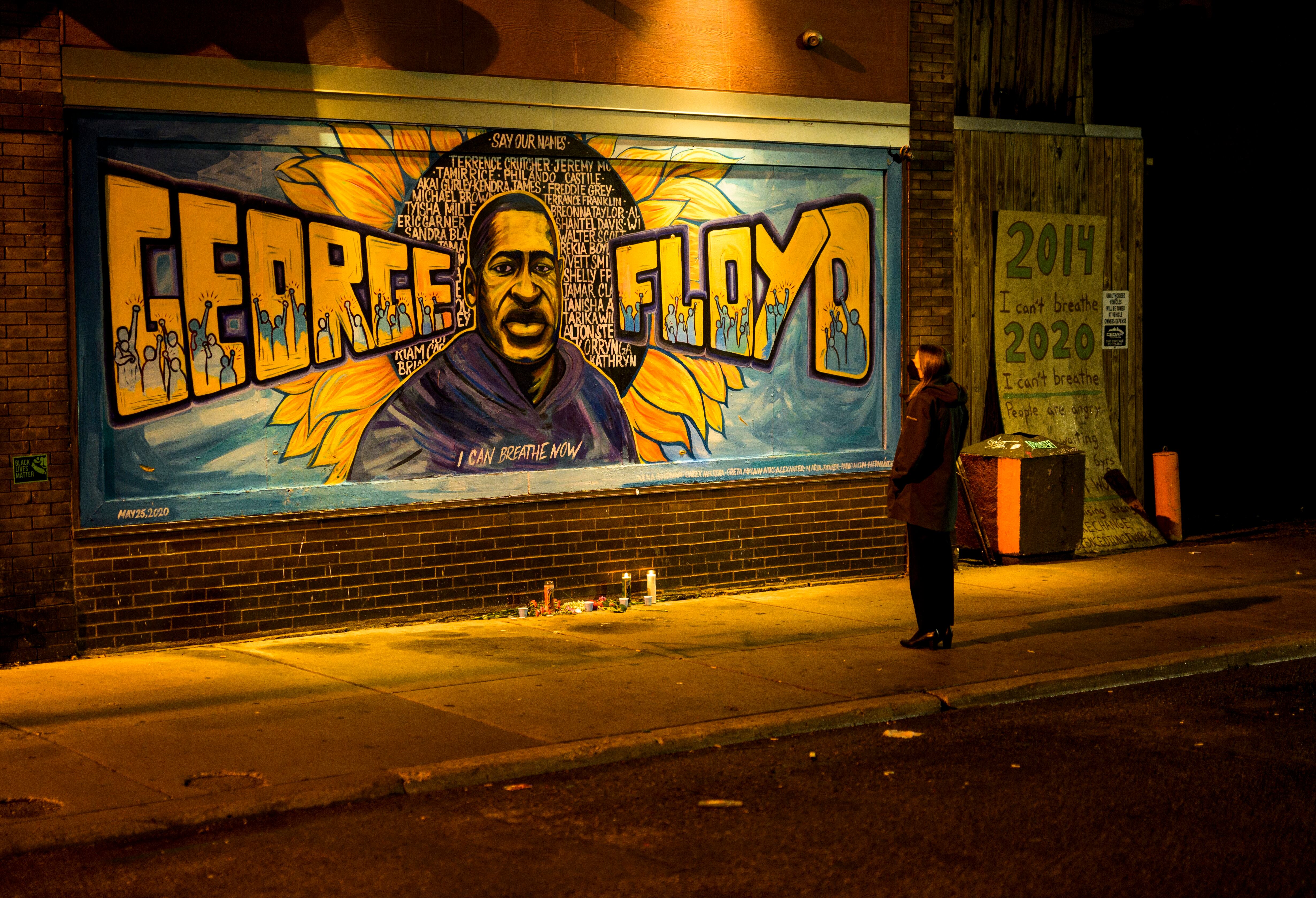 A woman looks at a mural on the wall of Cup Foods during a vigil for George Floyd on May 25, 2022 in Minneapolis, Minnesota.