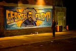 A woman looks at a mural on the wall of Cup Foods during a vigil for George Floyd on May 25, 2022 in Minneapolis, Minnesota.