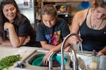 Althea Huesties-Wolf and her daughters Stella, center, and Manaia wash huckleberries and chokecherries in preparation for canning at their home on the Confederated Tribes of the Umatilla Indian Reservation near Mission, Oregon, last summer. These sacred first foods are considered “sisters” and are eaten at feasts and ceremonies throughout the year.