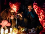 Women pause at a memorial at a vigil honoring the victims of a shooting at the Star Ballroom Dance Studio on Monday, Jan. 23, 2023, in Monterey Park, Calif.