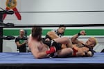 Oregon Pro Wrestling School owner and founder Ricky Gibson (left) records a match between Gunnar Thorson and Ocean Avery, with referee-in-training Maddie Medina enforcing the rules.